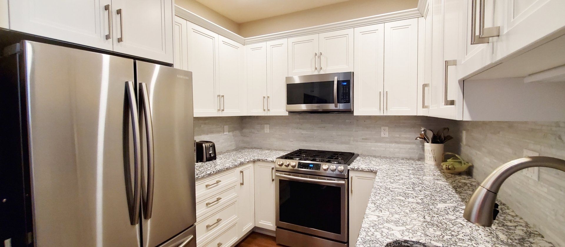 A kitchen with stainless steel appliances and granite counter tops.