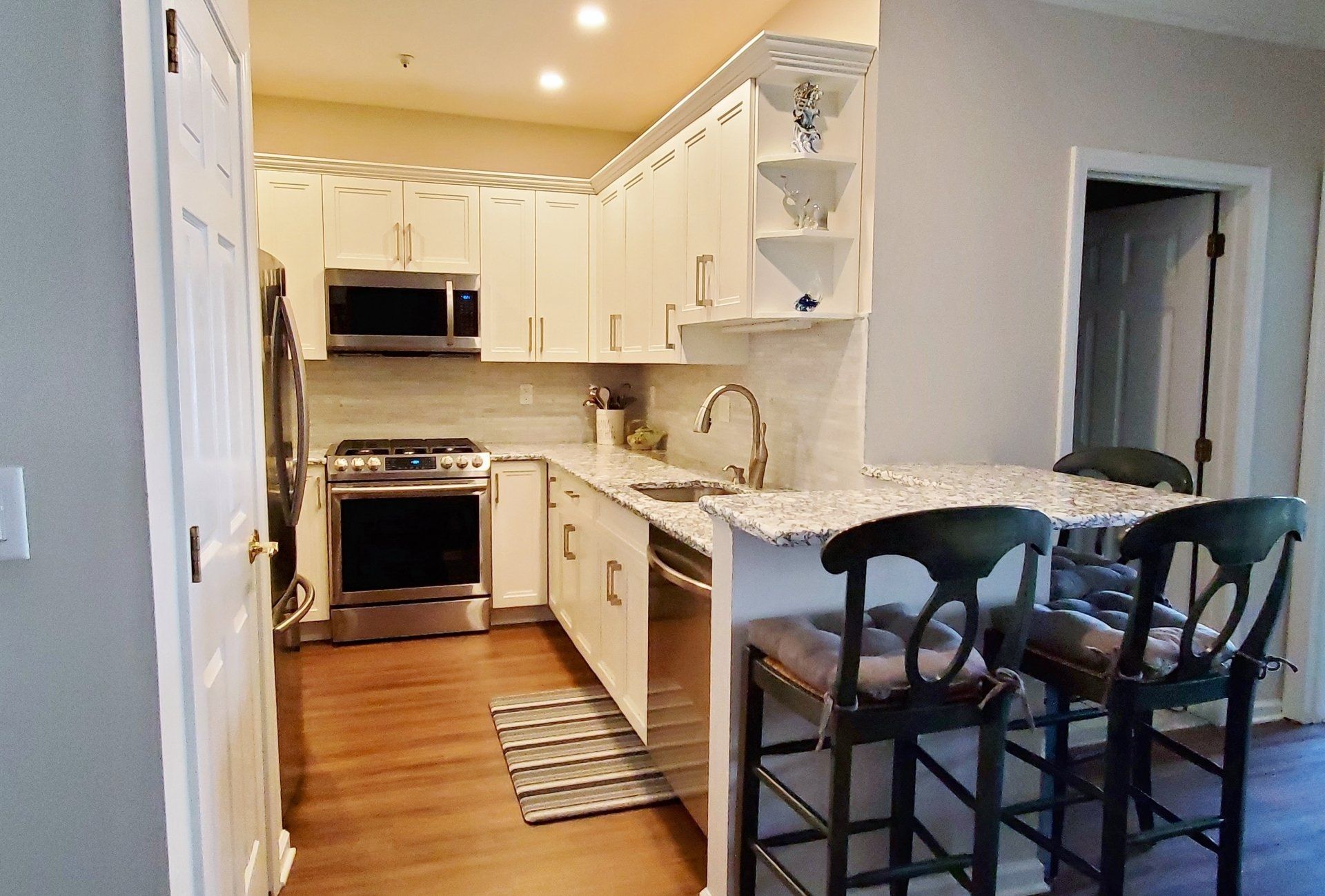 A kitchen with white cabinets and stainless steel appliances