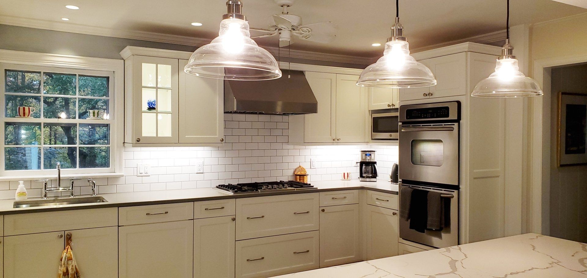 A kitchen with white cabinets and stainless steel appliances