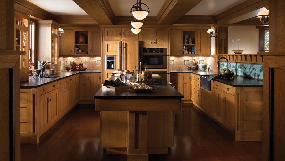 A kitchen with wooden cabinets and black counter tops
