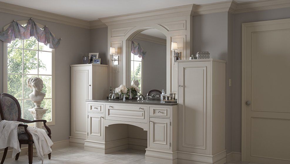 A bathroom with a vanity , sink , mirror and chair.