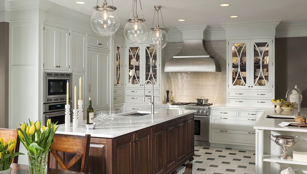 A kitchen with white cabinets and a large island in the middle.
