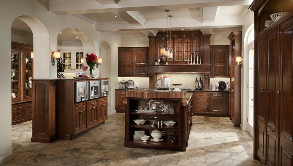 A kitchen with wooden cabinets and a large island in the middle