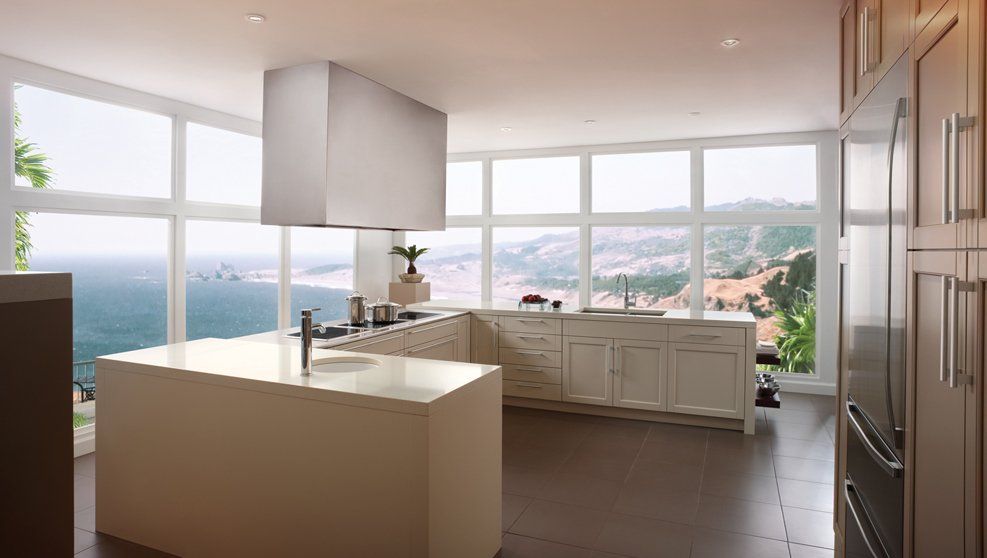 A kitchen with a large island and a view of the ocean.