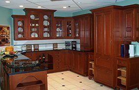 A kitchen with wooden cabinets and a black counter top.
