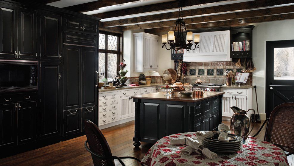 A kitchen with black cabinets and white counter tops