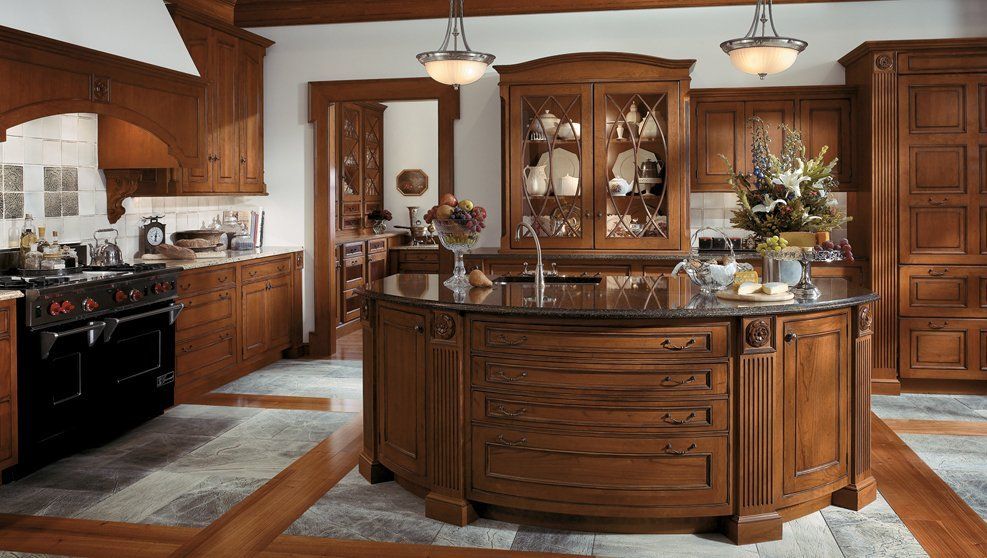 A kitchen with wooden cabinets and a large island in the middle