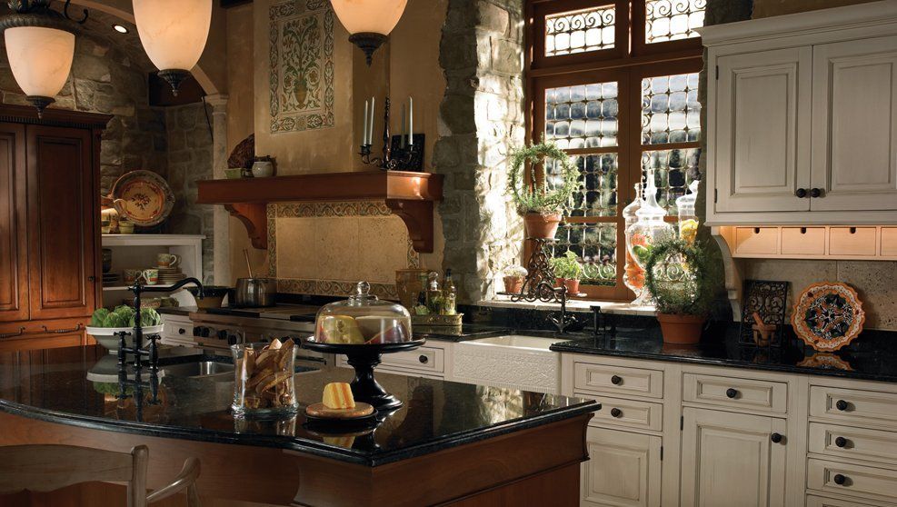 A kitchen with white cabinets and black counter tops
