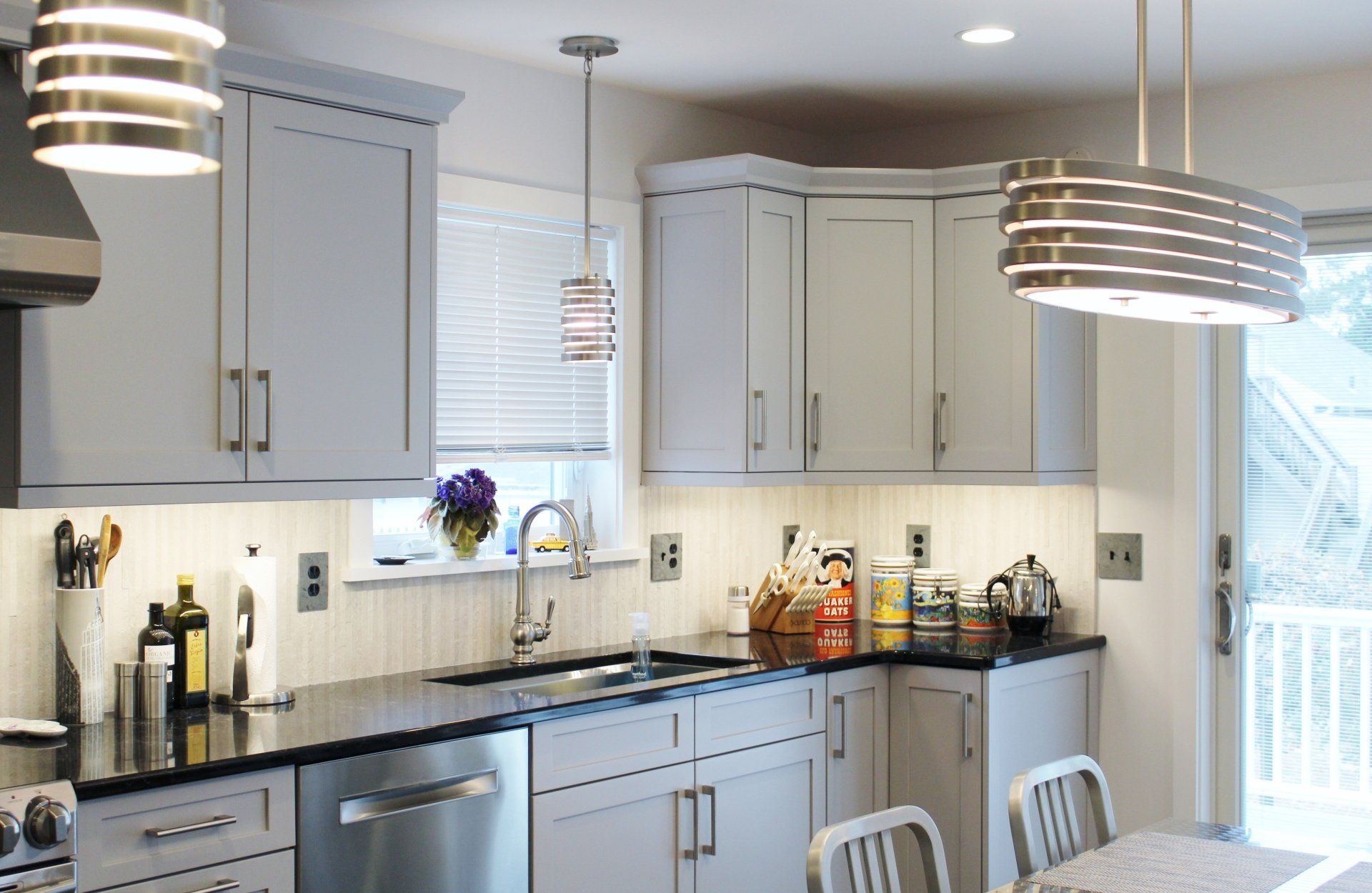 A kitchen with white cabinets and black counter tops