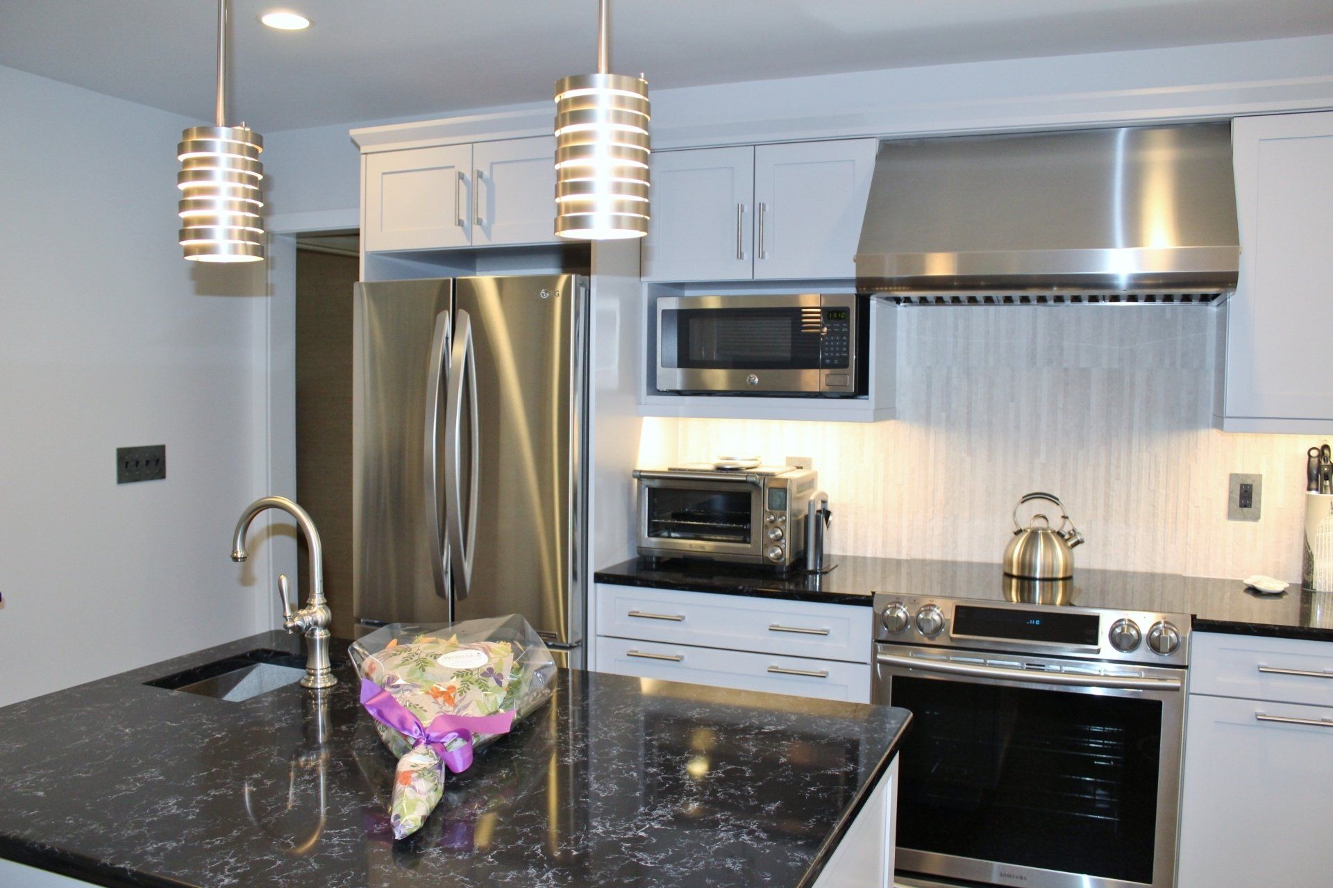 A kitchen with stainless steel appliances and black counter tops