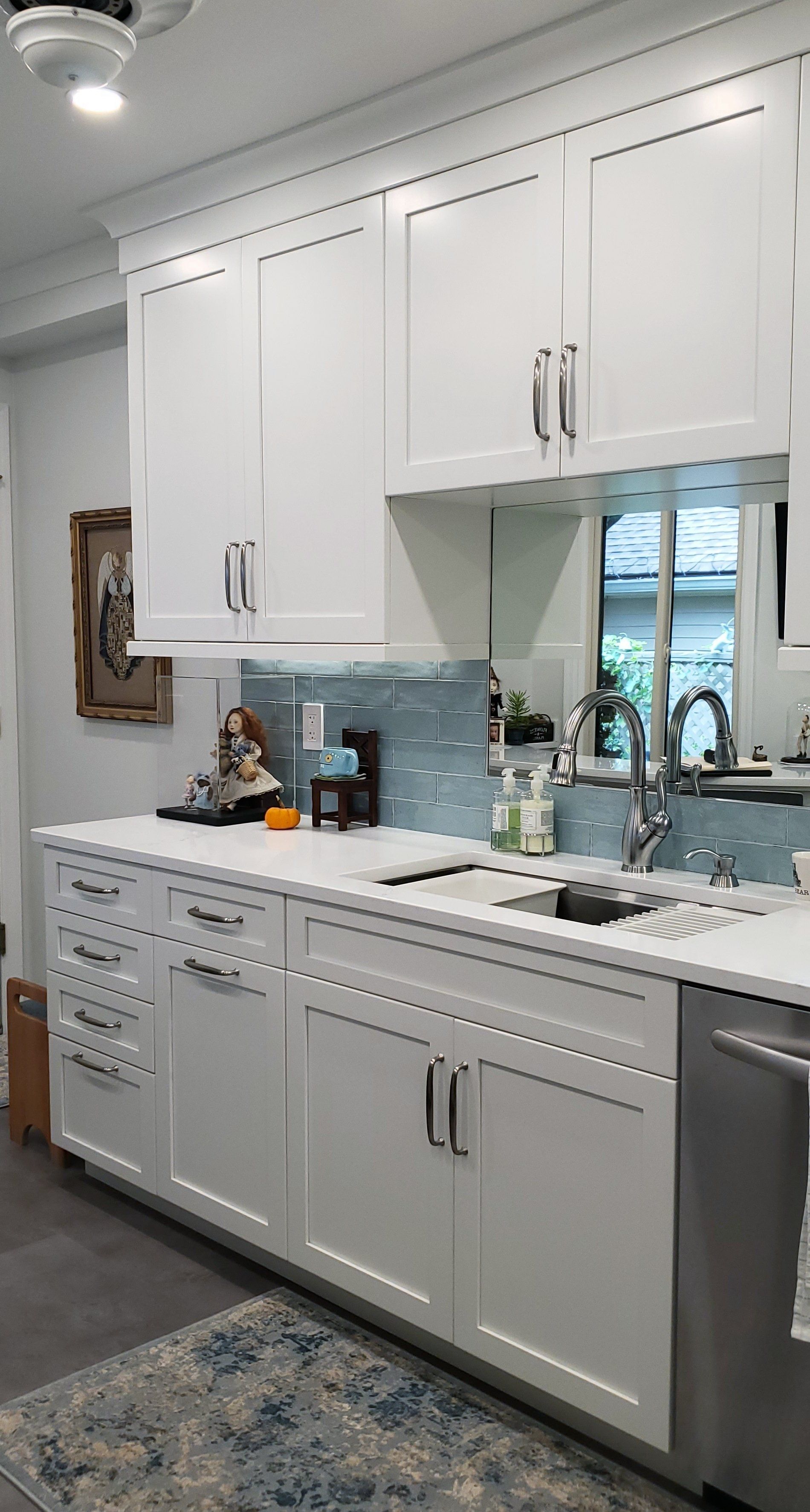 A kitchen with white cabinets and stainless steel appliances.