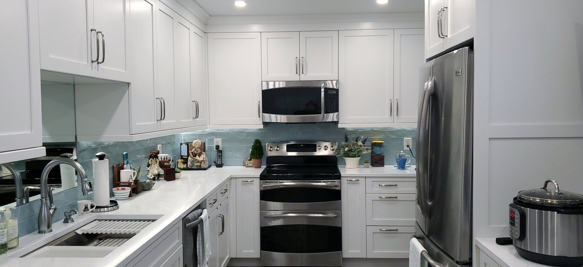 A kitchen with white cabinets and stainless steel appliances.