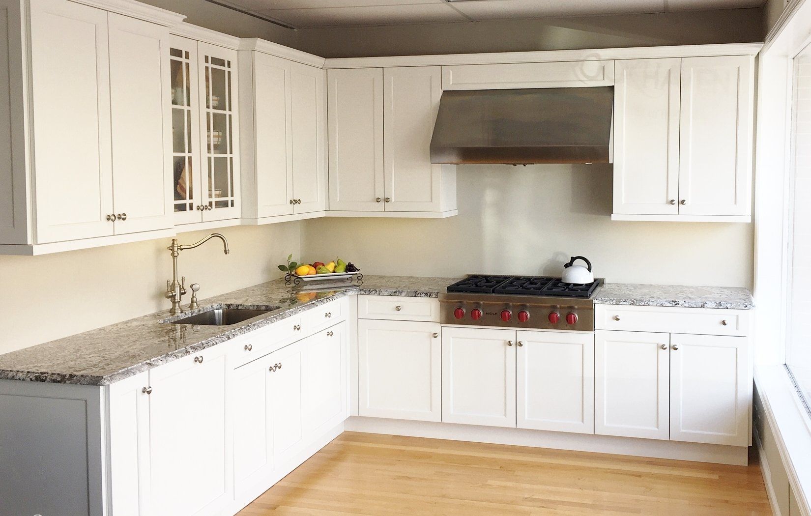 A kitchen with white cabinets and granite counter tops