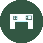 A white icon of a desk in a green circle.