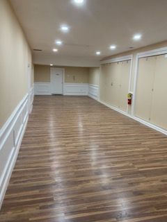 A large empty room with hardwood floors and white trim.