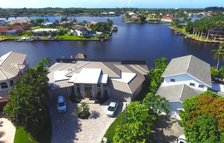 An aerial view of a house next to a body of water