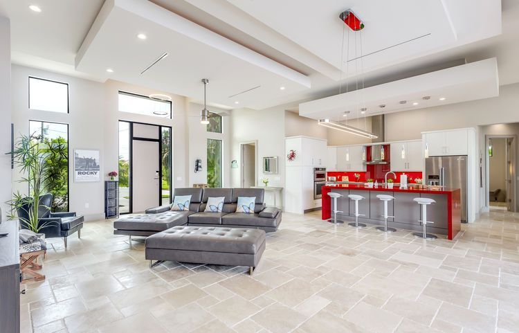 A modern house with two garages and a palm tree in front of it.