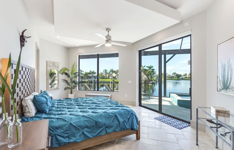 A bedroom with a large bed and a ceiling fan.