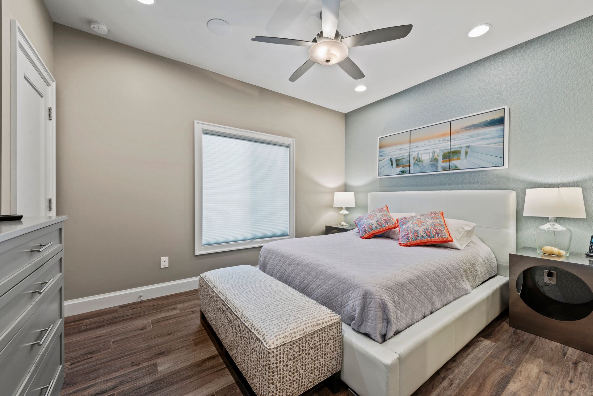 A bedroom with a large bed and a ceiling fan.