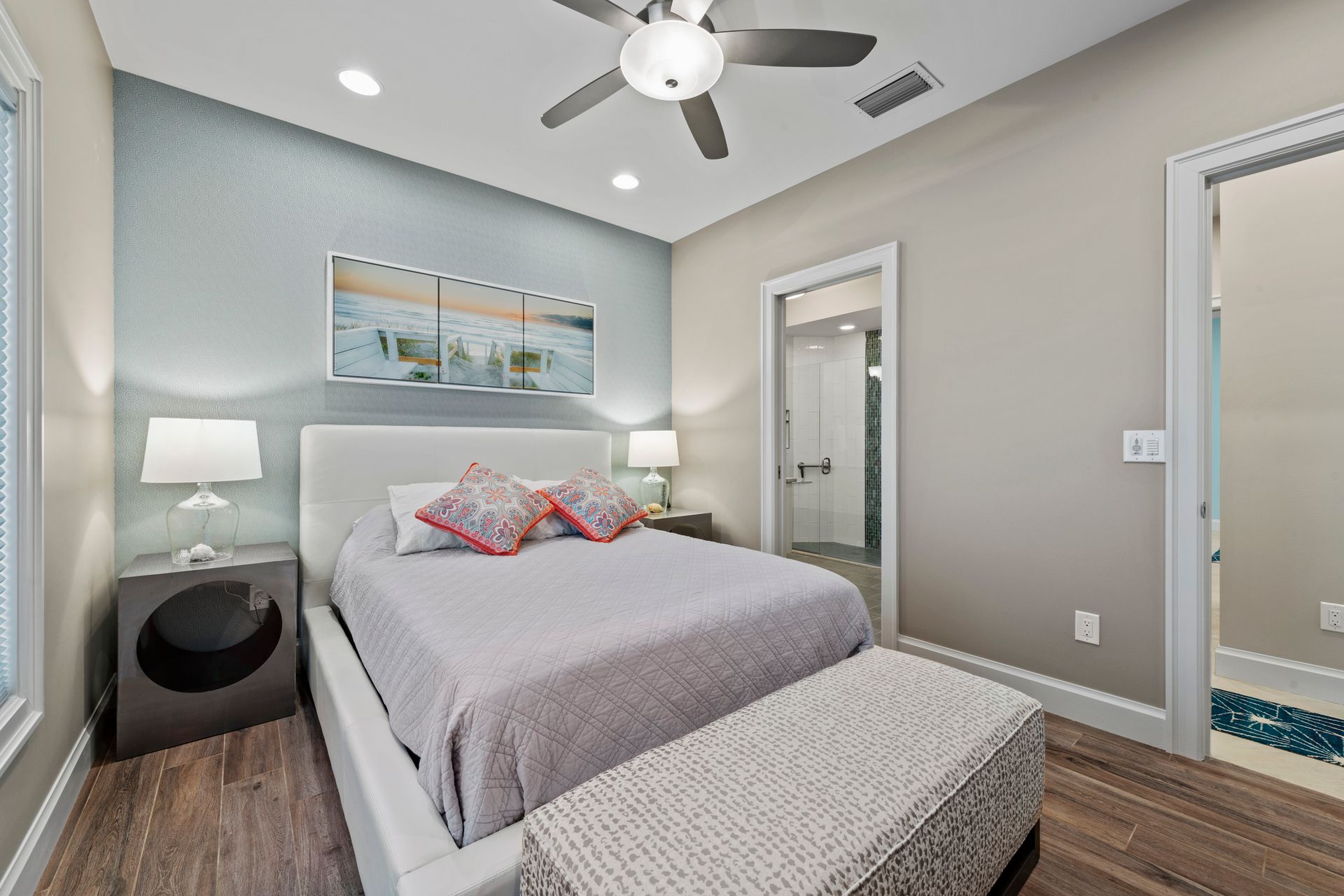A bedroom with a large bed and a ceiling fan.