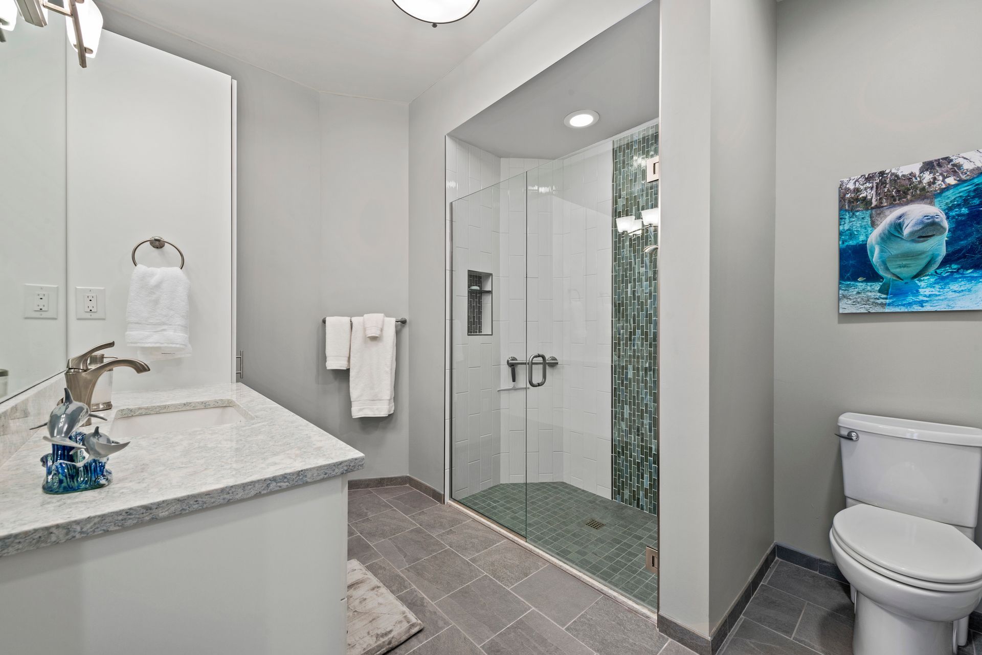 A bathroom with a toilet , sink , and walk in shower.