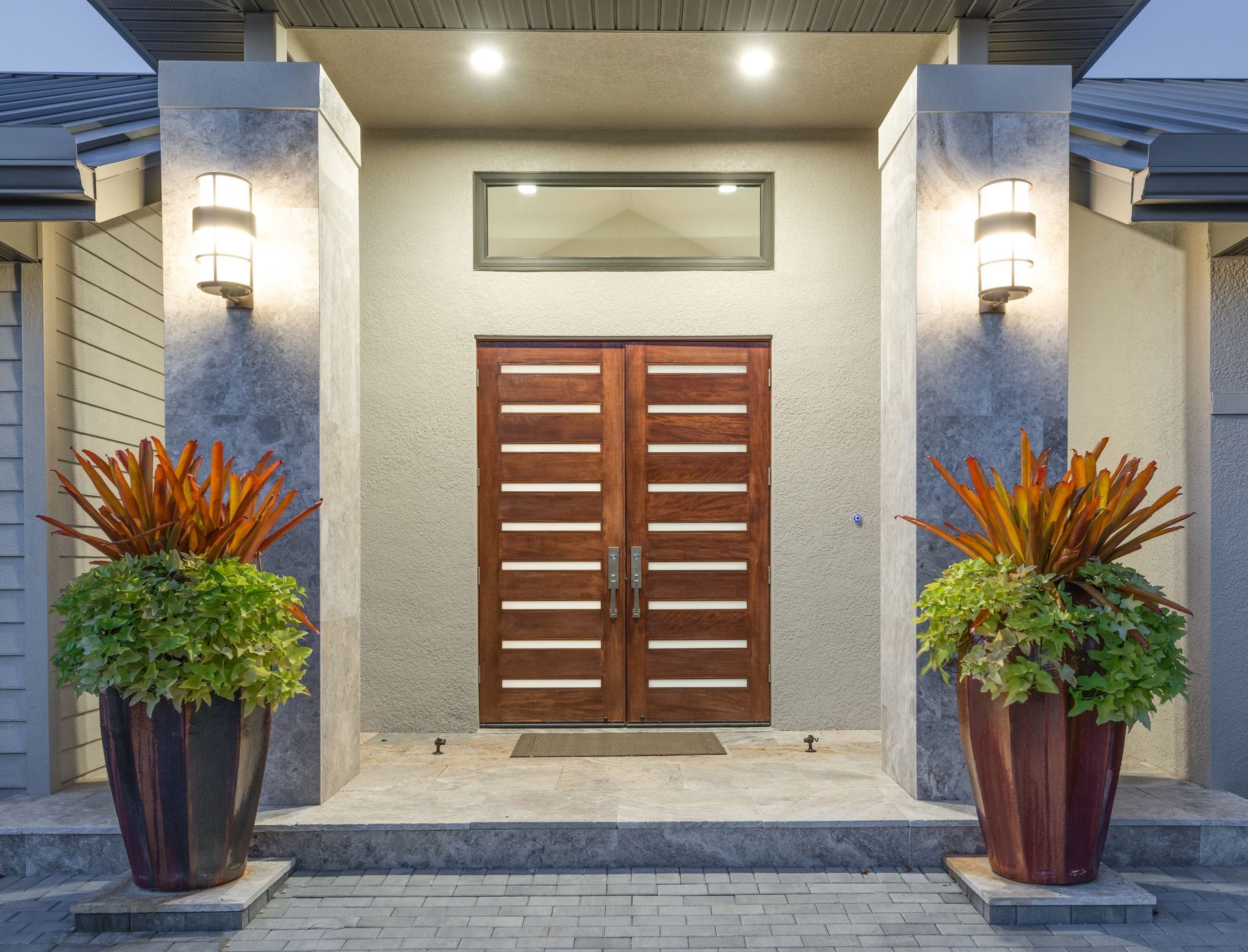 The front door of a house with two potted plants in front of it