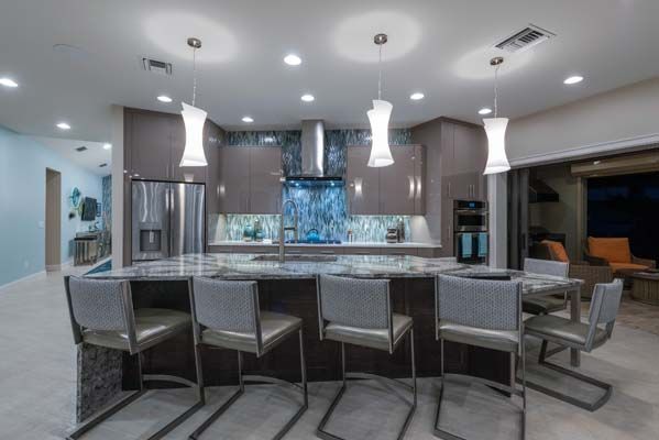 A kitchen with a large island and chairs in it