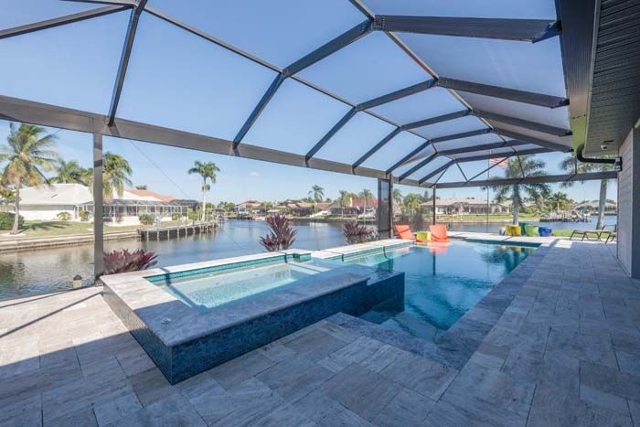 There is a large swimming pool in the backyard of a house.