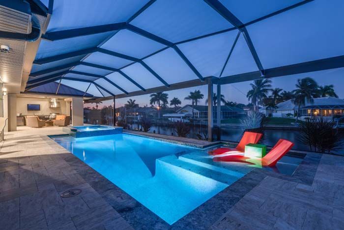 There is a large swimming pool in the backyard of a house.