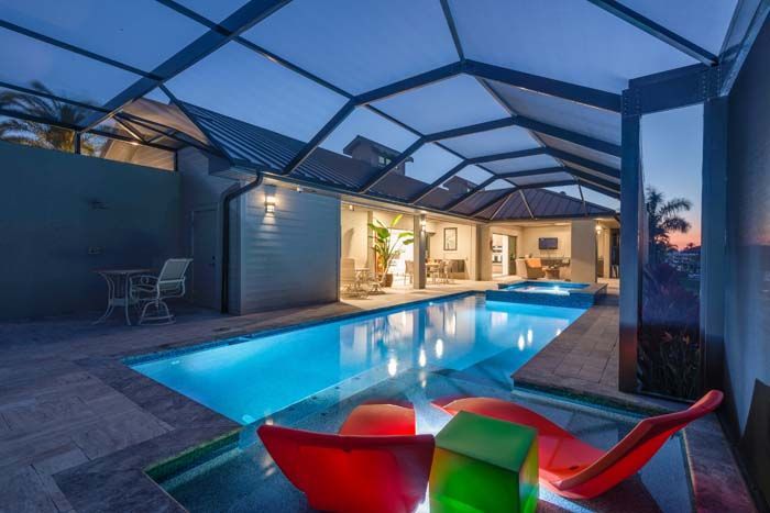 There is a large swimming pool in the backyard of a house.