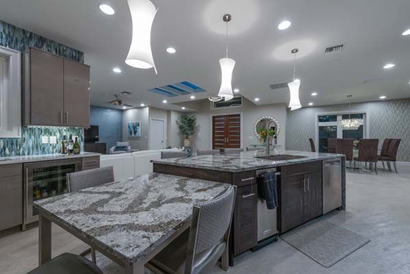 A kitchen with a table and chairs and a large island in the middle.