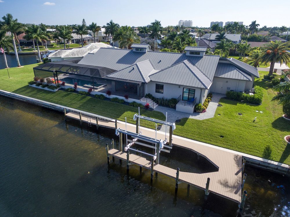 An aerial view of a house next to a body of water.