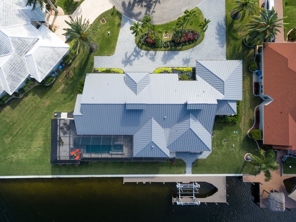 An aerial view of a house next to a body of water.