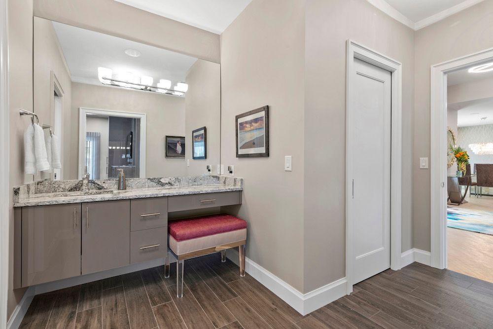 A bathroom with two sinks , a mirror and a bench.