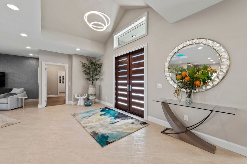 A living room with a table , mirror and rug.