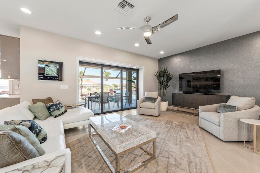A living room with a couch , chair , coffee table and television.