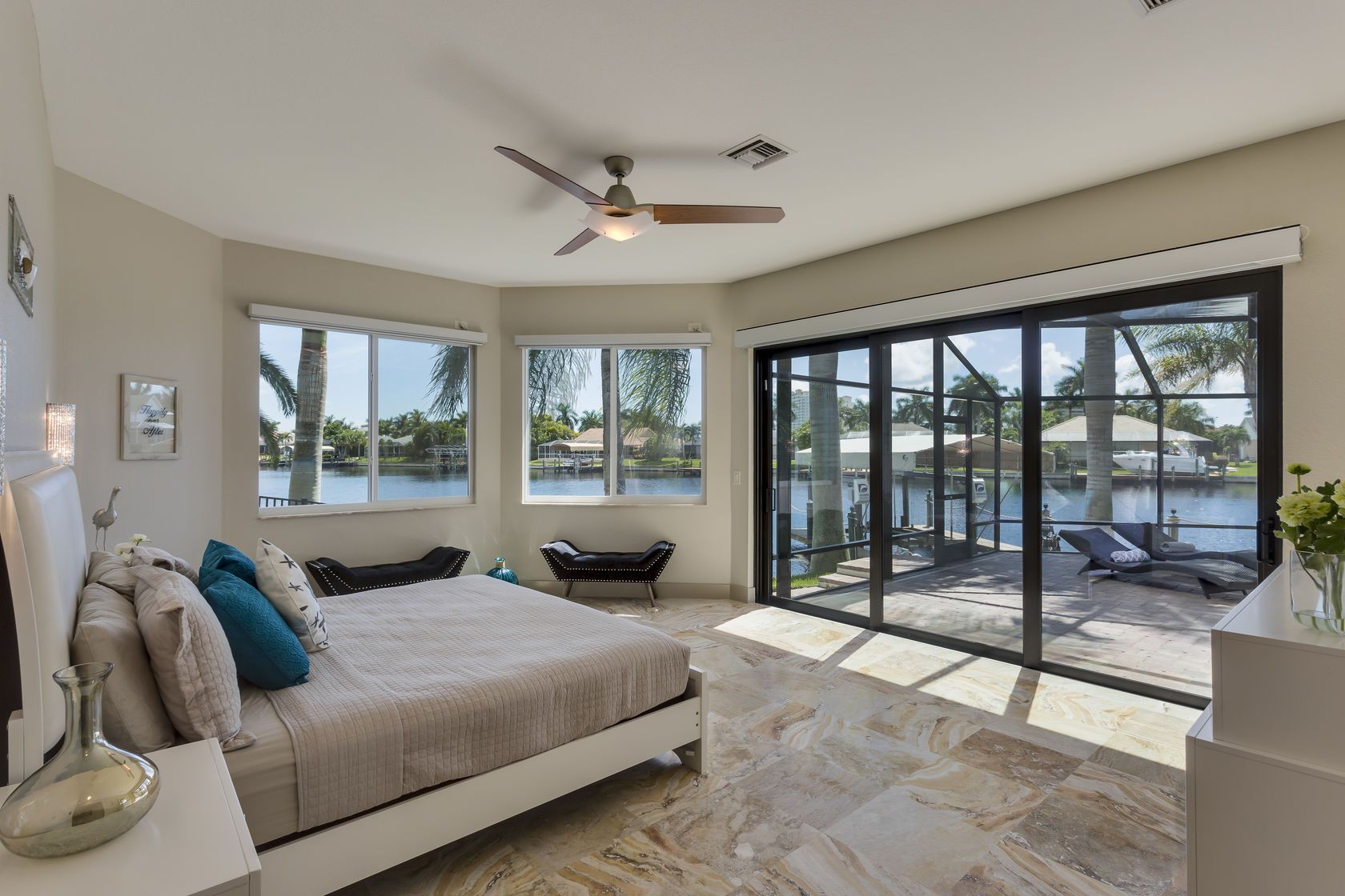A bedroom with a large bed and a ceiling fan