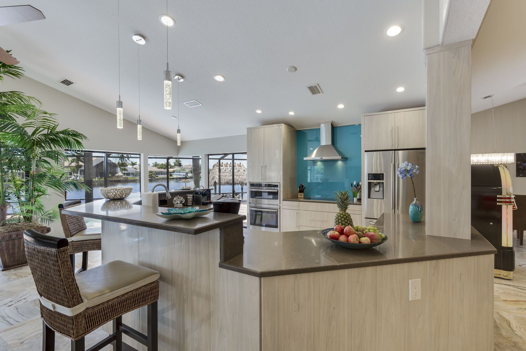 A kitchen with a large island and a bowl of fruit on the counter.