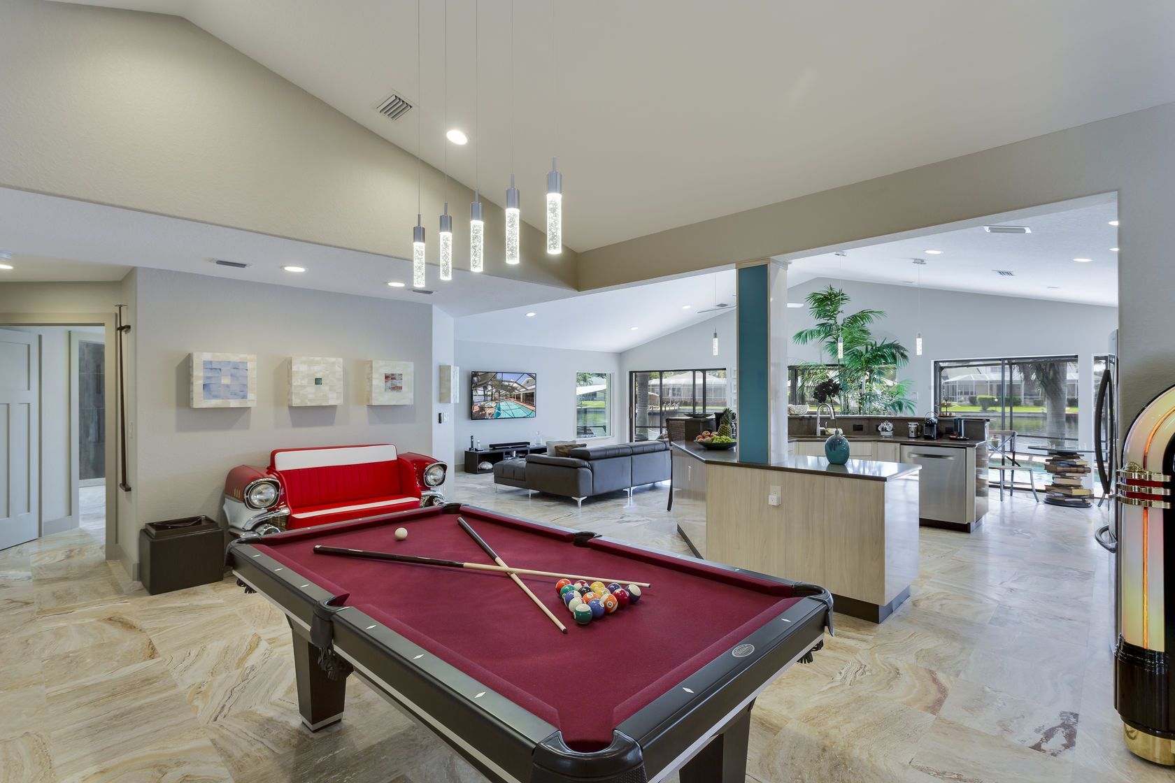 A pool table is in the middle of a living room.