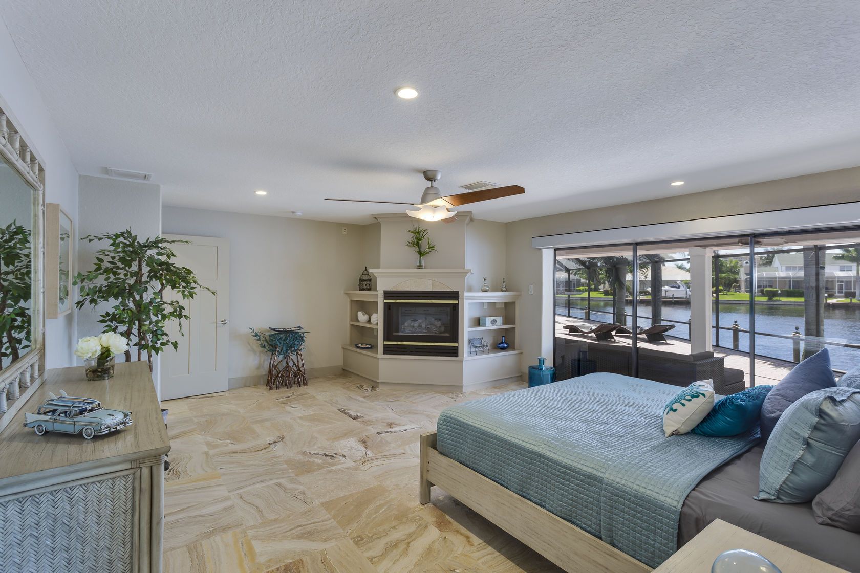 A bedroom with a large bed and a fireplace