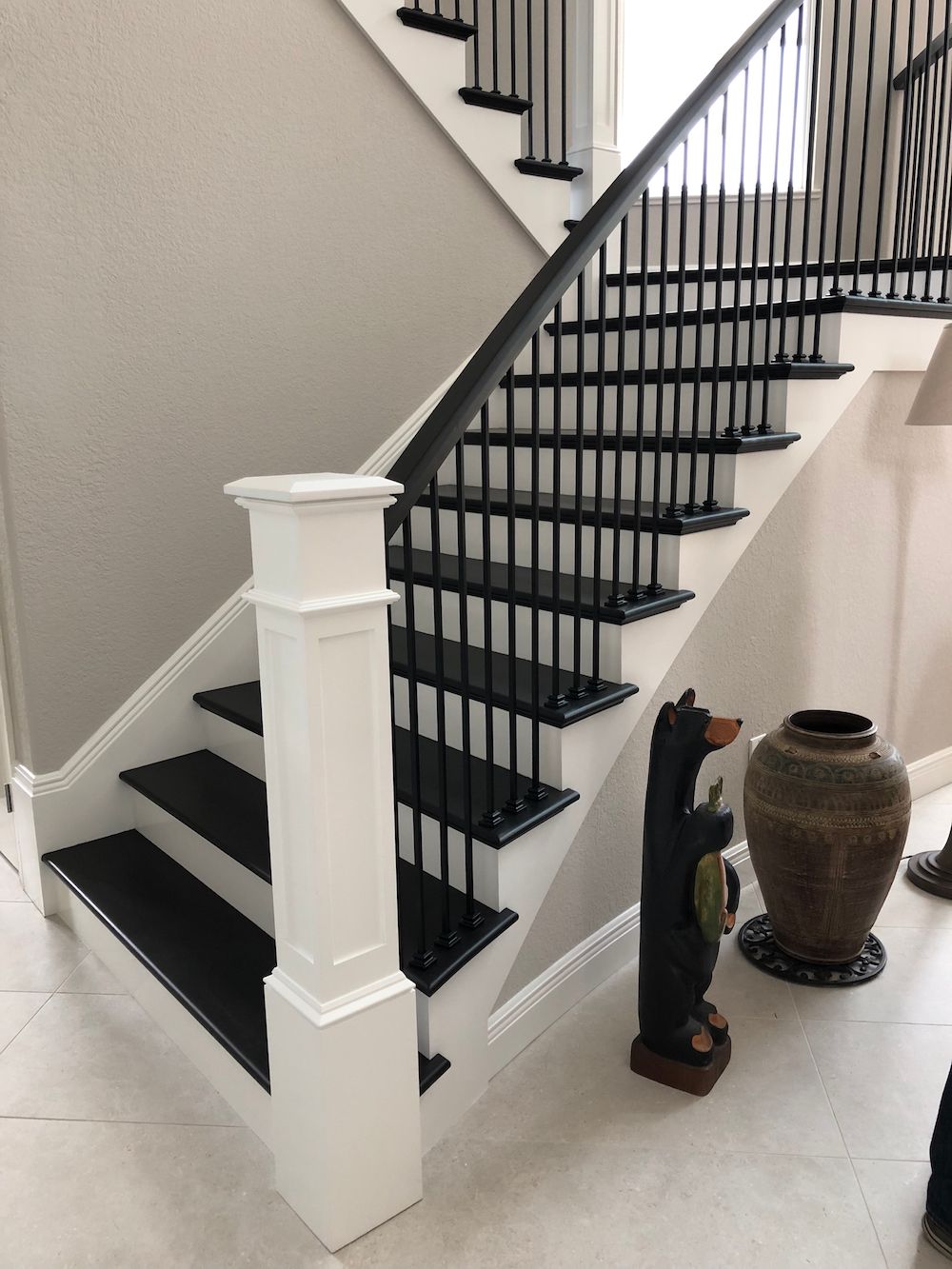 A staircase with black steps and a white railing