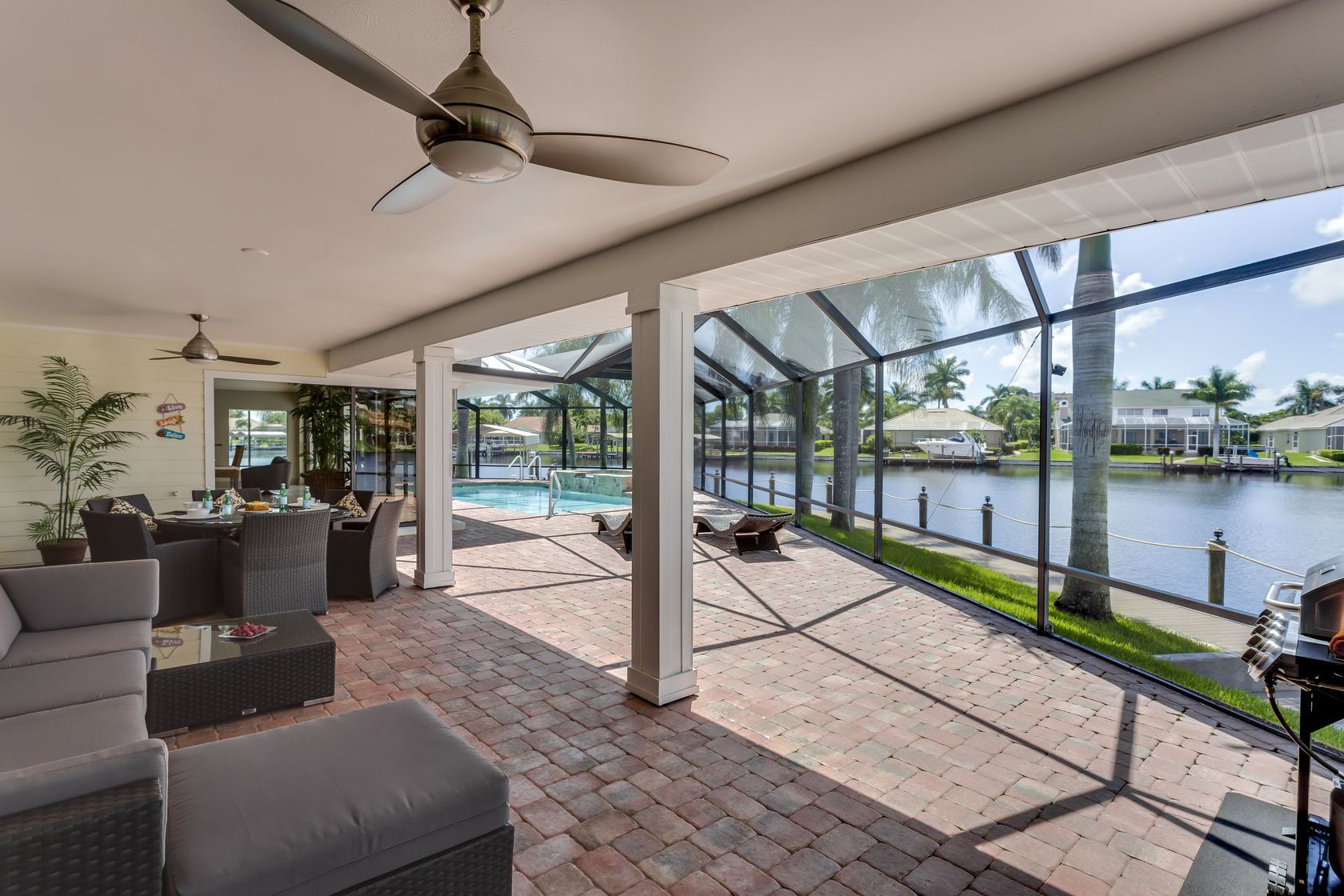 A living room with a ceiling fan and a view of a lake.