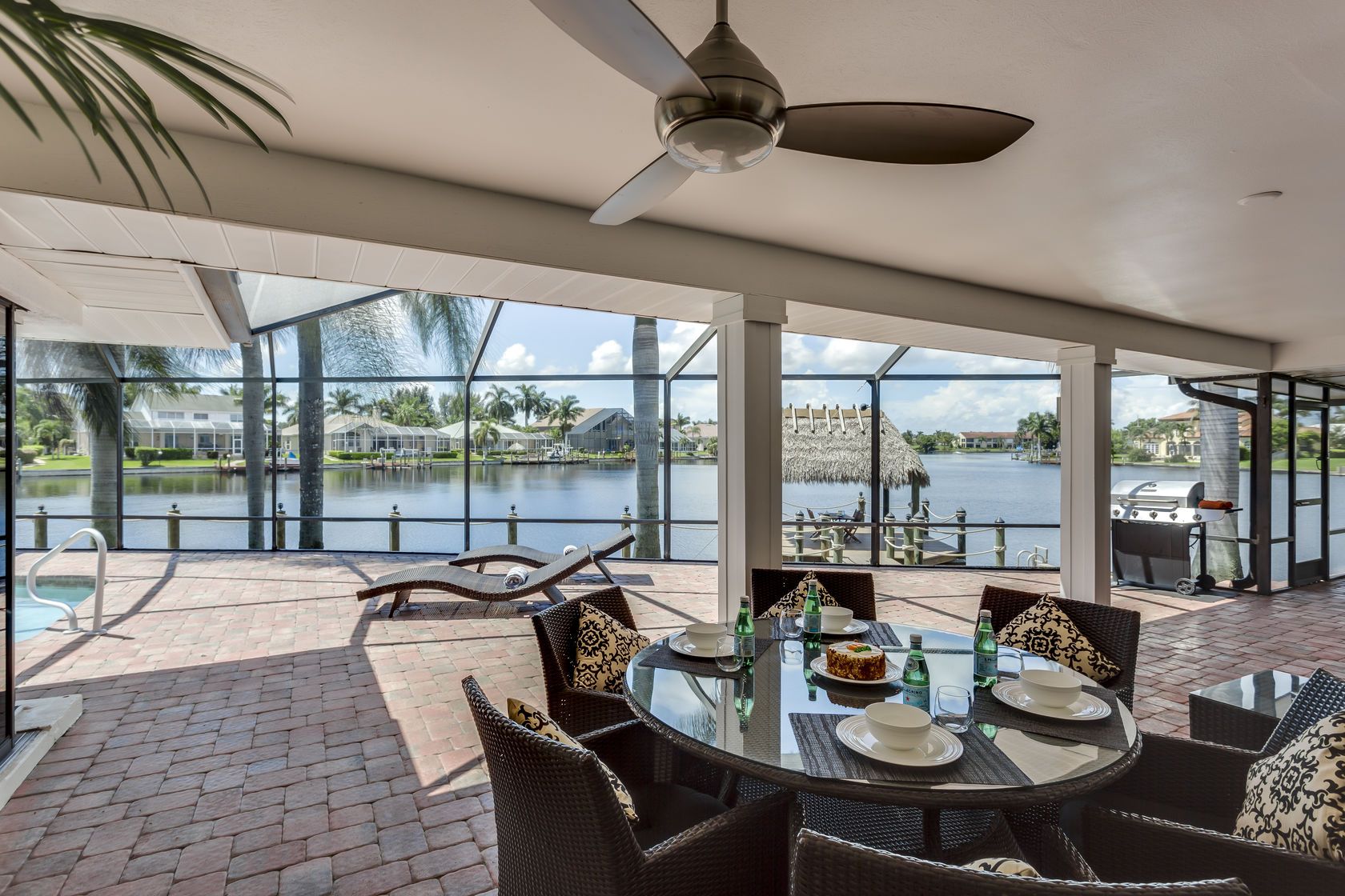 A patio with a table and chairs and a ceiling fan