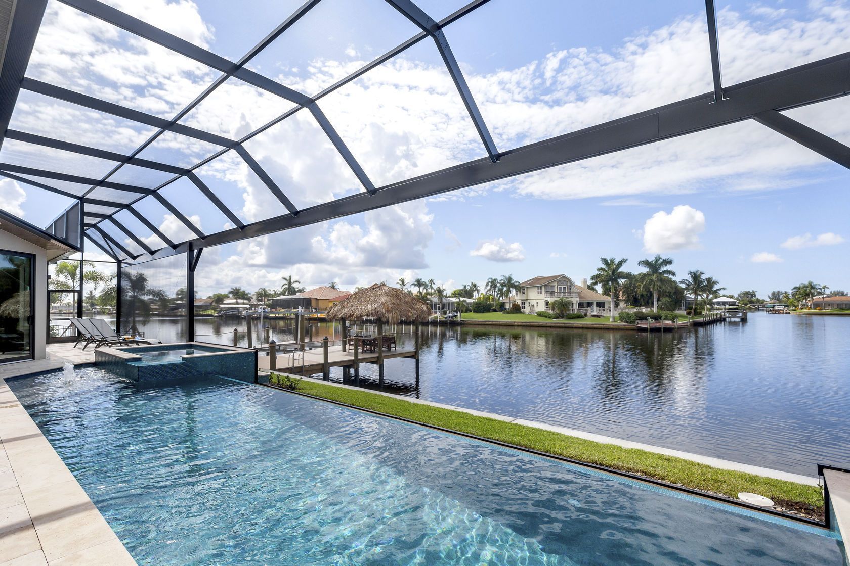 There is a large swimming pool with a view of the water.