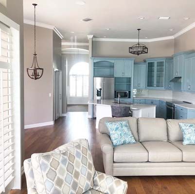 A living room with a couch , chair , and kitchen.