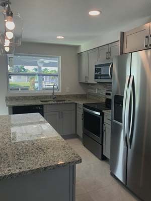 A kitchen with stainless steel appliances and granite counter tops.
