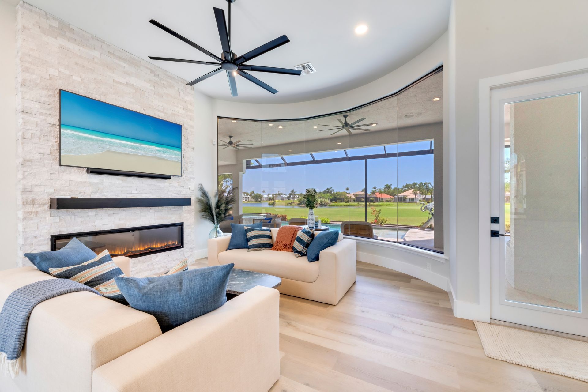 A living room with a couch , chair , fireplace and ceiling fan.