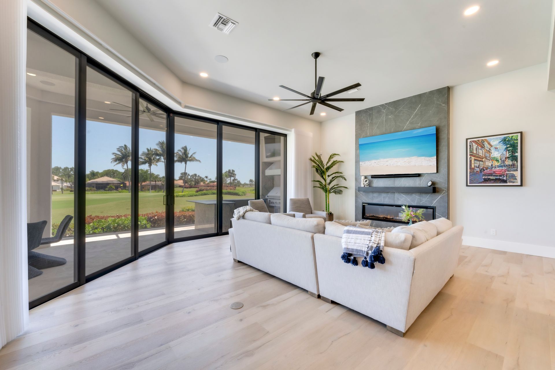 A living room with a couch , fireplace , television and sliding glass doors.
