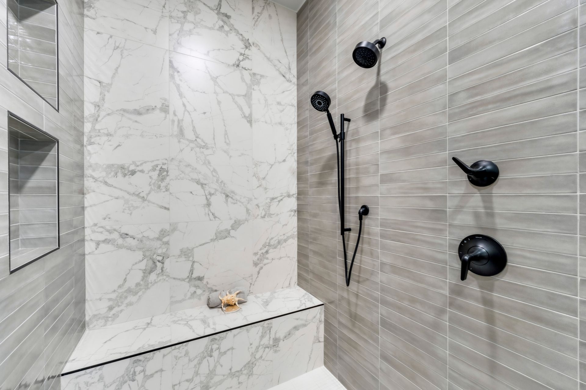 A bathroom with marble walls and a walk in shower.