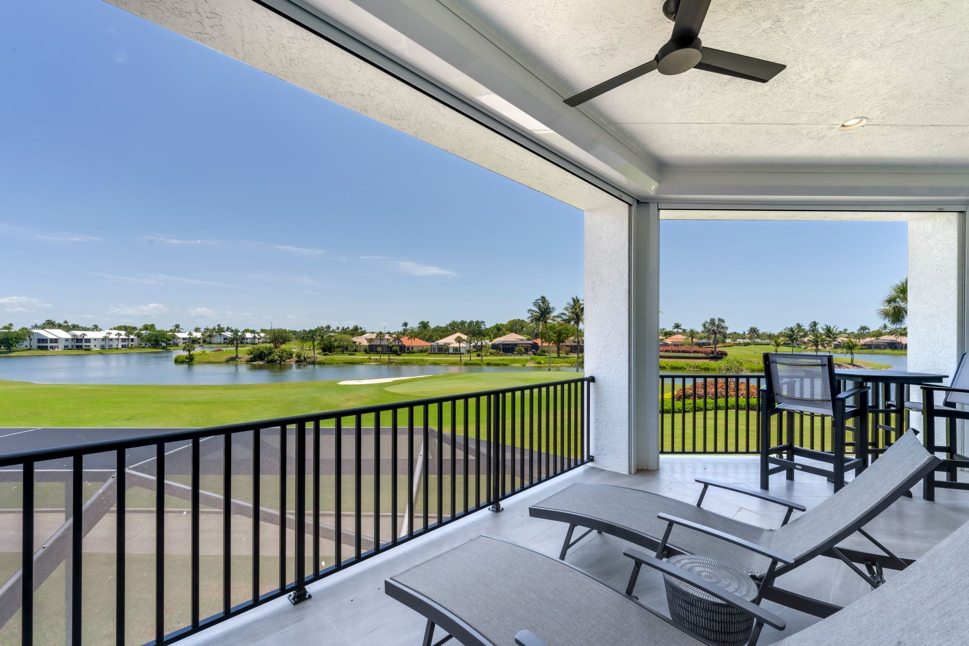 A balcony with a view of a golf course and a lake